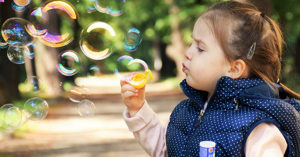 criança brincando com bolinhas de sabão